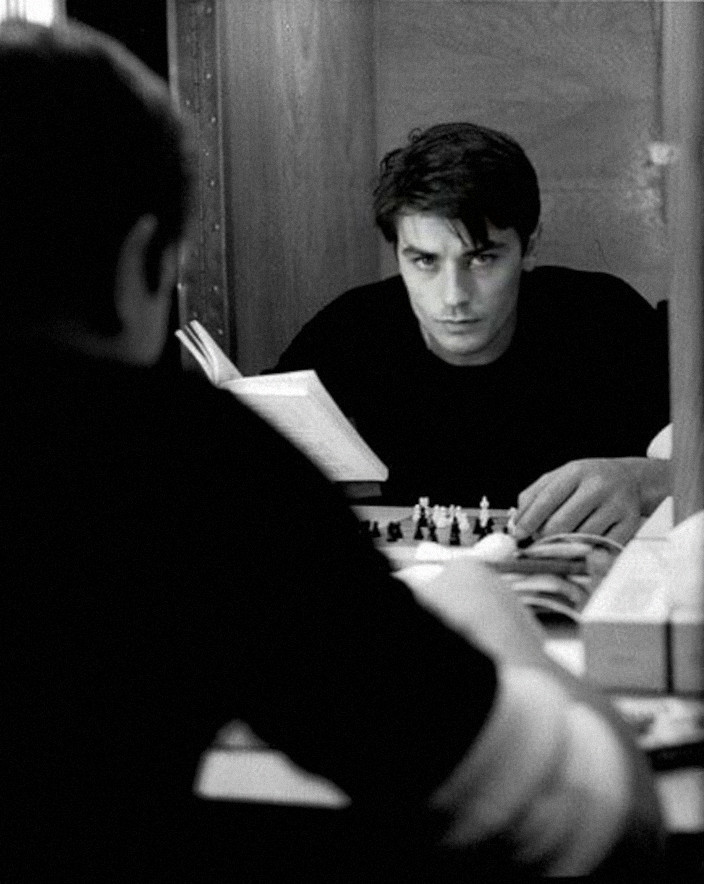 Alain Delon reading a book and playing with himself
