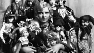 A young woman poses with her collection of boudoir dolls in Paris, 1922